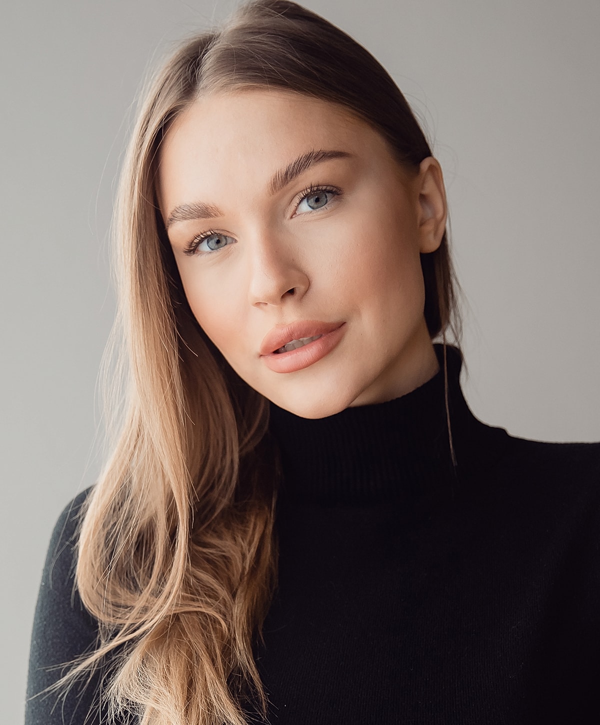 Woman with long hair in a black turtleneck.